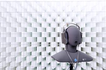 The picture shows an exhibit in form of an head in a silent room [anechoic chamber] of the faculty of media.